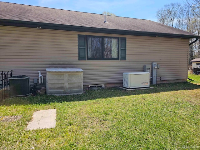 back of house featuring central AC and a lawn