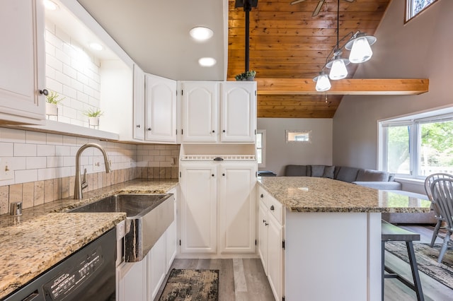 kitchen featuring light hardwood / wood-style floors, white cabinetry, light stone counters, dishwasher, and vaulted ceiling