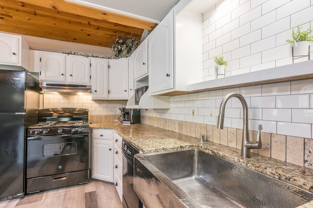 kitchen featuring black appliances, light hardwood / wood-style floors, tasteful backsplash, and white cabinetry