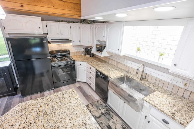 kitchen with light hardwood / wood-style flooring, white cabinets, backsplash, and black appliances