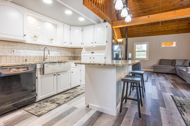 kitchen with dishwasher, hardwood / wood-style flooring, tasteful backsplash, white cabinetry, and light stone countertops