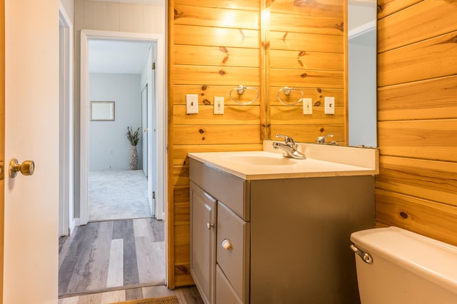 bathroom with toilet, vanity, and hardwood / wood-style flooring