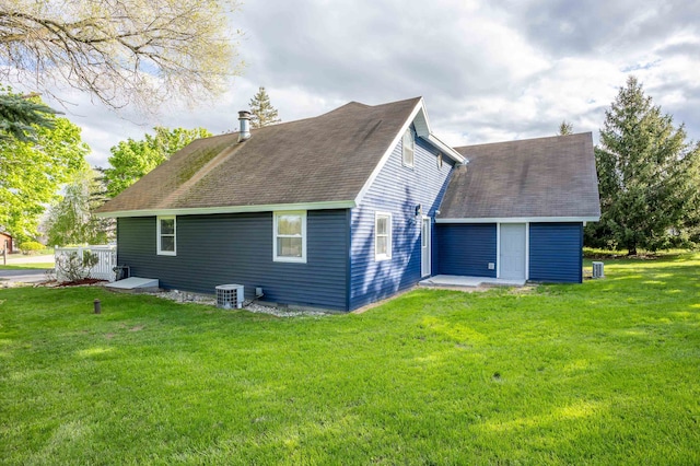 back of house with central AC and a lawn