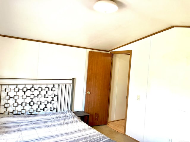 bedroom featuring lofted ceiling, crown molding, and light wood-type flooring