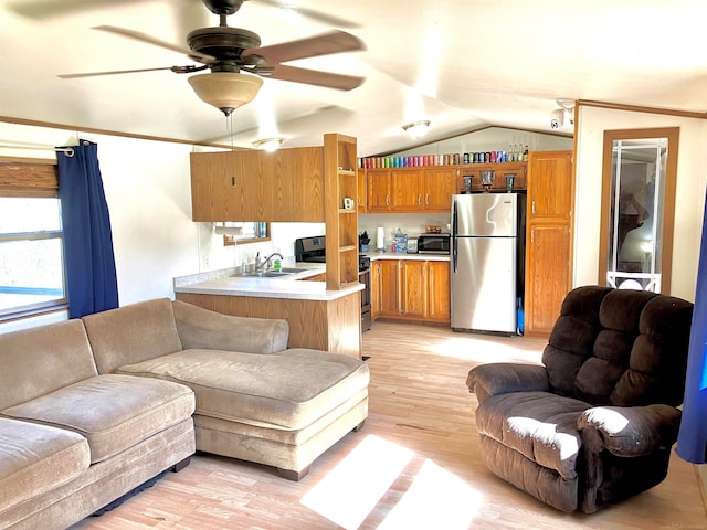 living room with light hardwood / wood-style flooring, ceiling fan, ornamental molding, sink, and lofted ceiling