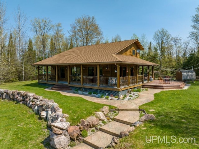 rear view of property featuring a porch and a yard