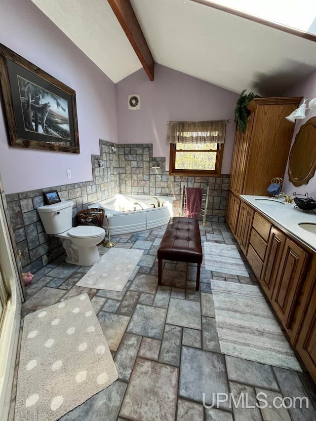 bathroom featuring tile flooring, a tub, vaulted ceiling with beams, toilet, and vanity