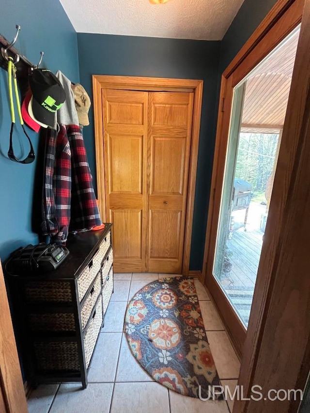 entryway featuring a textured ceiling and light tile flooring