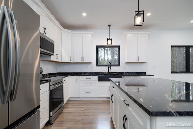 kitchen with pendant lighting, appliances with stainless steel finishes, sink, and a healthy amount of sunlight