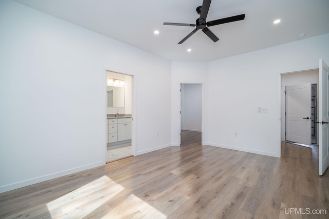 unfurnished bedroom featuring ceiling fan, ensuite bathroom, and light hardwood / wood-style floors