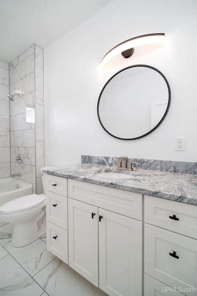 full bathroom featuring tiled shower / bath, vanity, and toilet