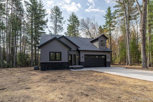 view of front of property with a garage and central AC