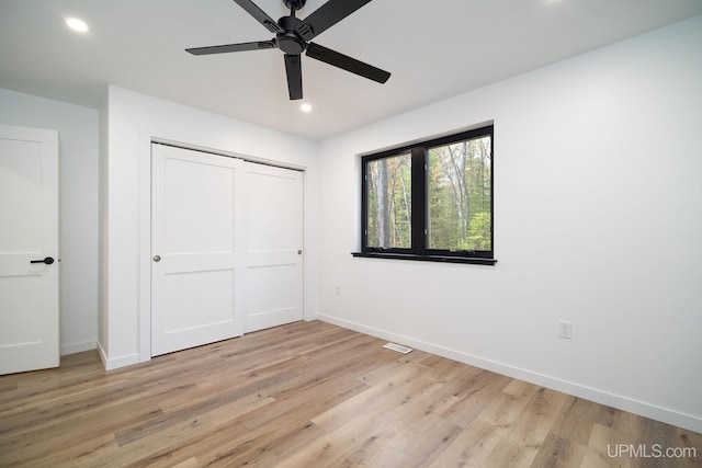 unfurnished bedroom featuring a closet, light hardwood / wood-style floors, and ceiling fan