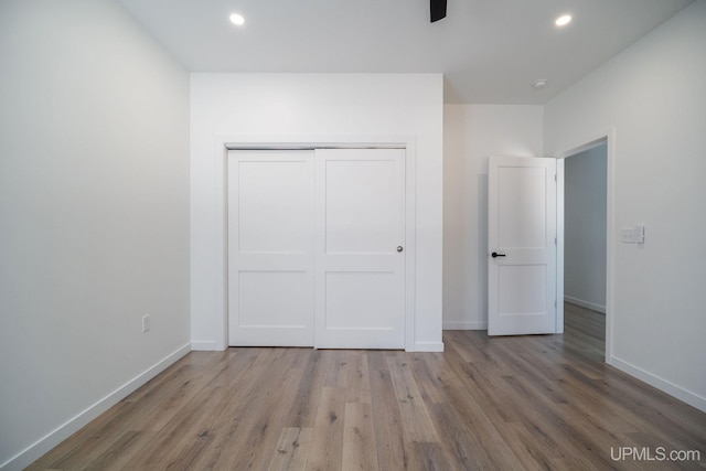 unfurnished bedroom with a closet and light hardwood / wood-style floors