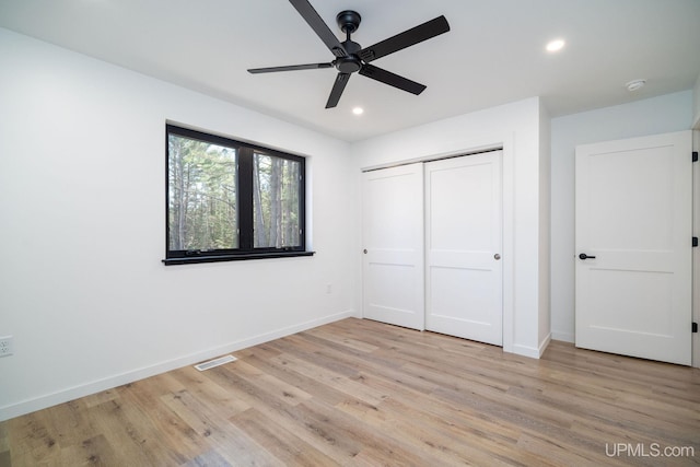 unfurnished bedroom with ceiling fan, a closet, and light hardwood / wood-style floors