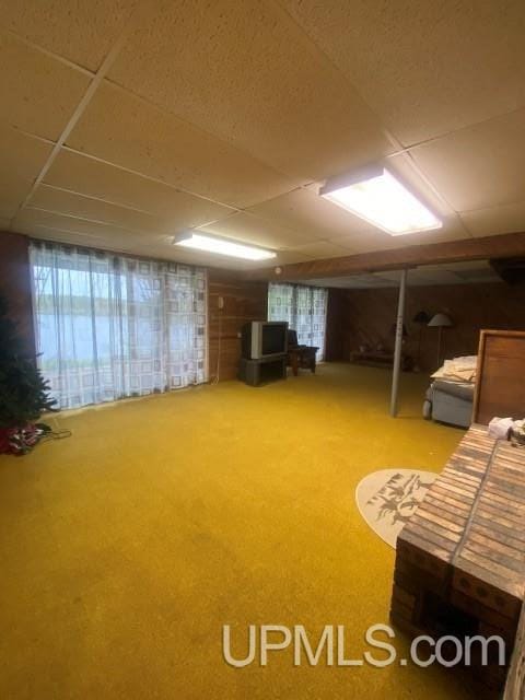 basement featuring a paneled ceiling and carpet