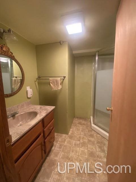 bathroom with a shower with door and vanity