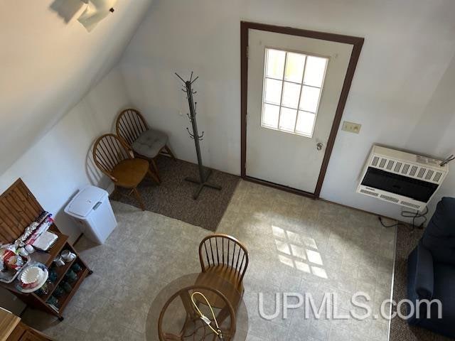 interior space with vaulted ceiling and heating unit