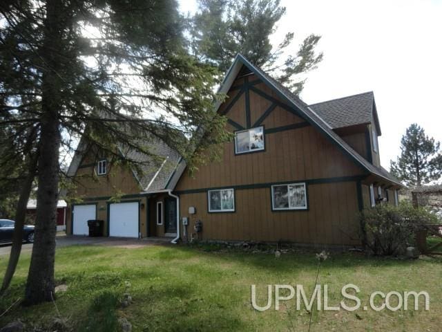 exterior space featuring a garage and a lawn