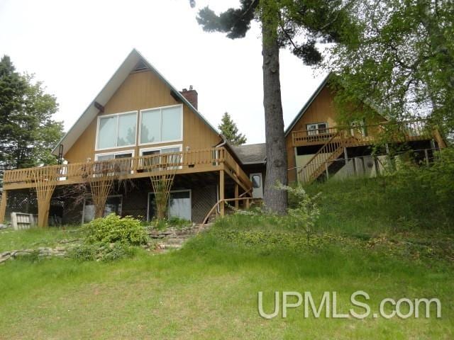 rear view of house featuring a wooden deck