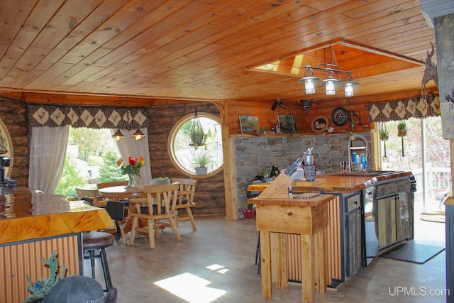 kitchen with wooden ceiling, sink, wooden walls, and wooden counters