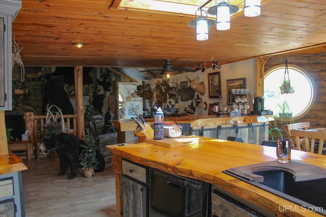 kitchen featuring hanging light fixtures, ceiling fan, black dishwasher, wood-type flooring, and wood ceiling