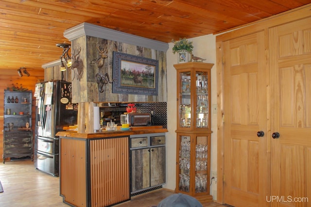 kitchen featuring hardwood / wood-style floors, stainless steel fridge, and wood ceiling