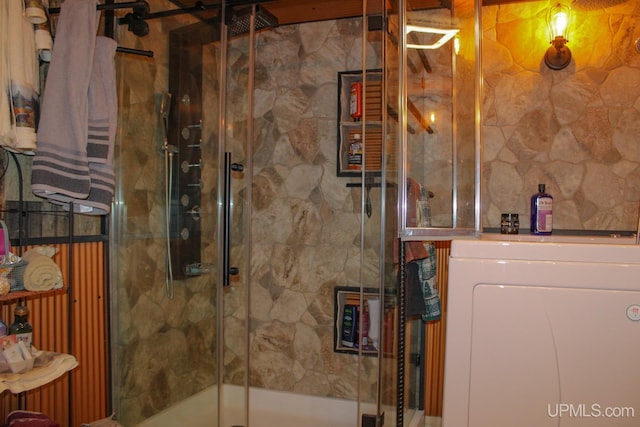 bathroom featuring walk in shower and washer / dryer