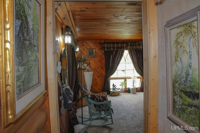 unfurnished room with wood walls, carpet, and wood ceiling