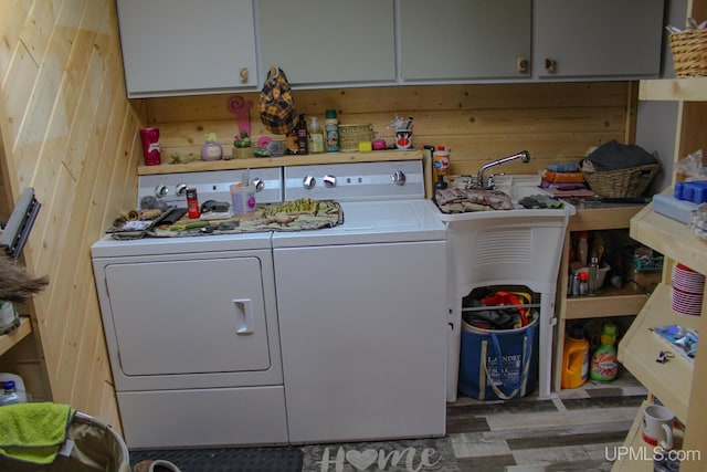 laundry area with dark hardwood / wood-style flooring, wood walls, cabinets, and independent washer and dryer