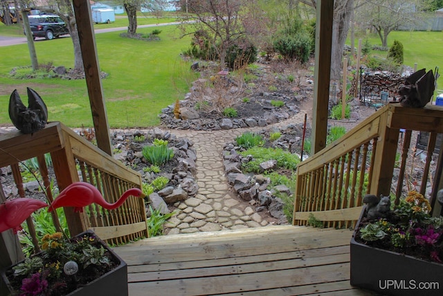 wooden deck featuring a lawn