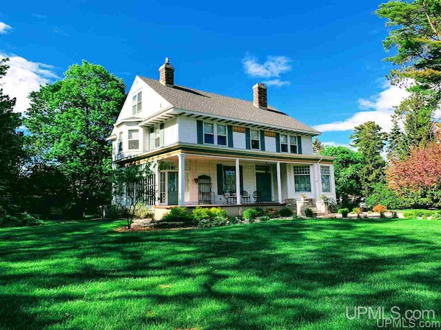 view of front of house with a front yard and a porch