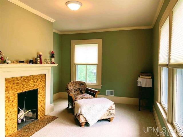 living area with a tiled fireplace, carpet floors, and ornamental molding