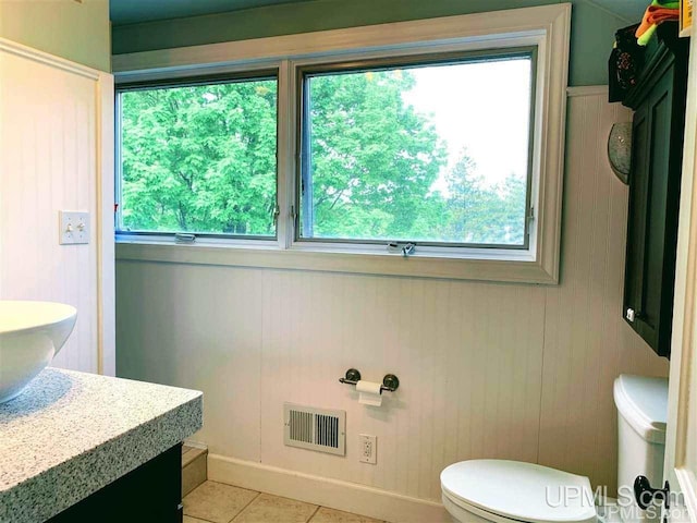 bathroom featuring plenty of natural light, vanity, toilet, and tile floors