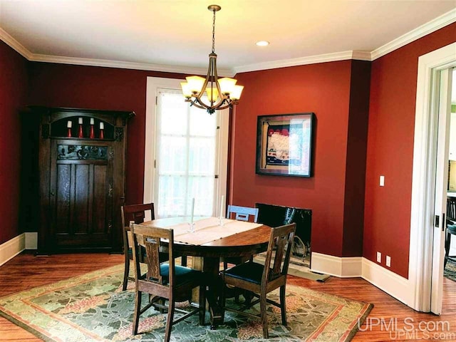 dining room featuring dark hardwood / wood-style flooring, a chandelier, and crown molding