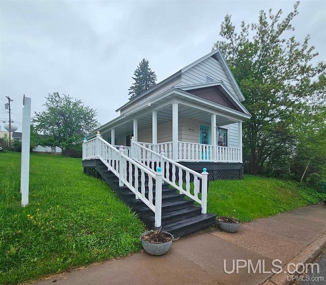 view of front of property with a porch and a front lawn