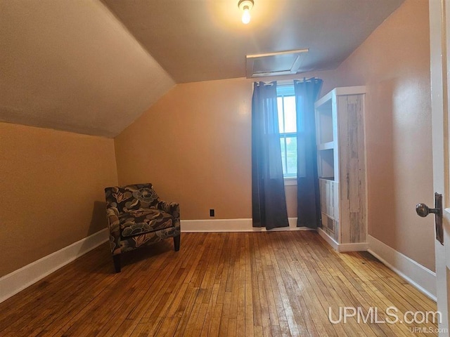 unfurnished room with light wood-type flooring and vaulted ceiling