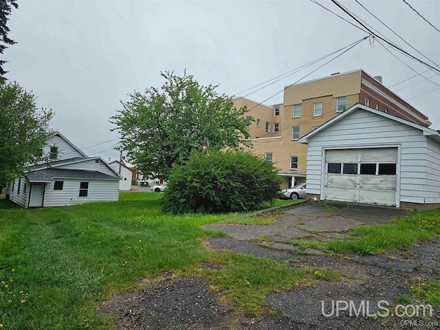 exterior space with a lawn, an outbuilding, and a garage