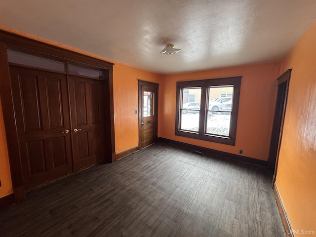 unfurnished bedroom with dark hardwood / wood-style flooring and a closet