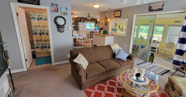 carpeted living room with ceiling fan