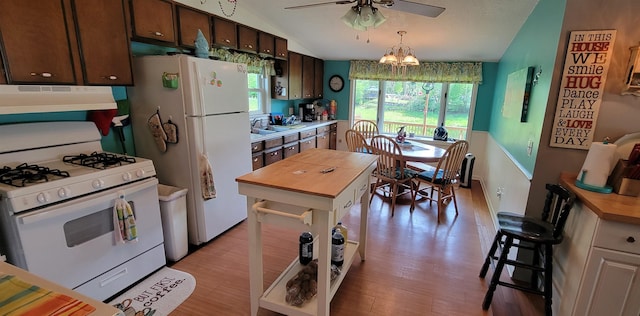 kitchen featuring butcher block counters, light wood-type flooring, ceiling fan with notable chandelier, white appliances, and fume extractor