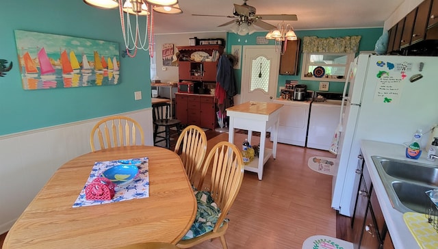 dining space featuring washer and dryer, sink, hardwood / wood-style flooring, and ceiling fan