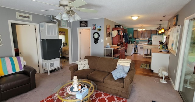 carpeted living room with ceiling fan and a textured ceiling