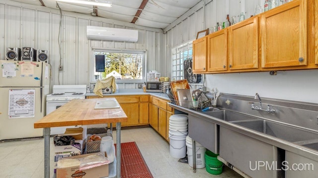 kitchen with white refrigerator, light tile flooring, and a wall mounted air conditioner