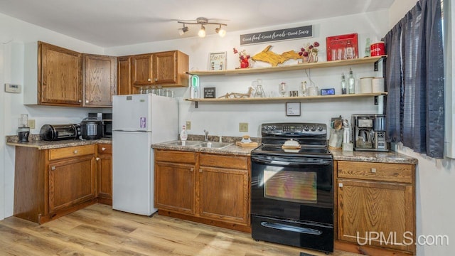 kitchen featuring sink, black electric range oven, white fridge, and light wood-type flooring