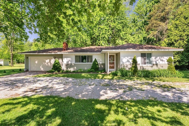 single story home with a garage and a front lawn