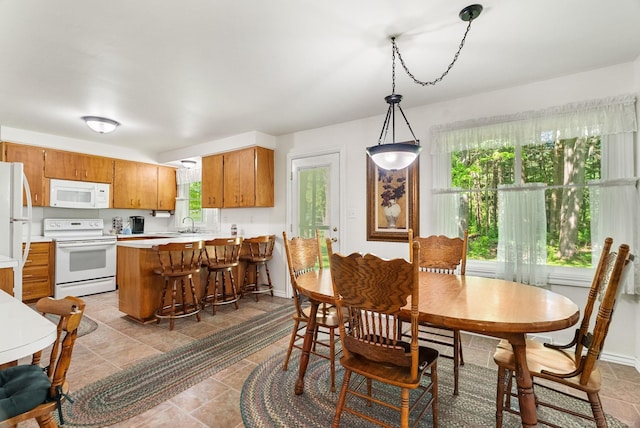 dining space featuring sink and light tile floors