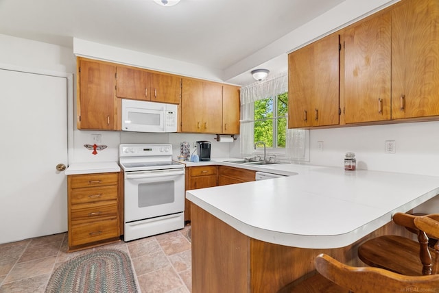 kitchen with kitchen peninsula, white appliances, light tile flooring, sink, and a breakfast bar area