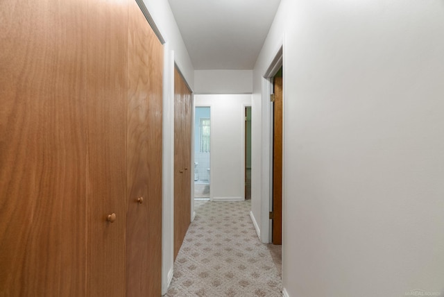 hallway featuring light colored carpet