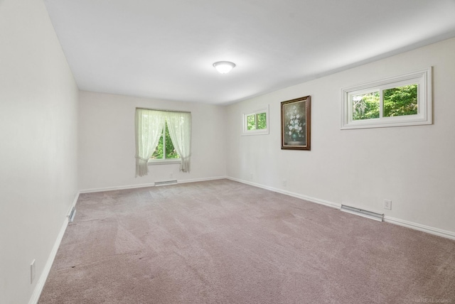 empty room with carpet flooring and baseboard heating